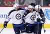 Charles Rex Arbogast / The Associated Press
Winnipeg Jets defenceman Jay Harrison, left, and Andrew Ladd (right) celebrate with Zach Bogosian after Bogosian's goal Friday in Chicago.