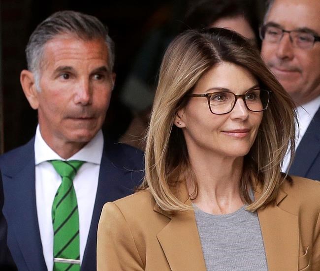 Actress Lori Loughlin, front, and husband, clothing designer Mossimo Giannulli, left, depart federal court in Boston on Wednesday, April 3, 2019, after facing charges in a nationwide college admissions bribery scandal. (AP Photo/Steven Senne)