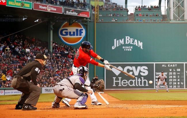 Boston Red Sox's J.D. Martinez connects for an RBI single against the Colorado Rockies during the first inning of a baseball game Wednesday, May 15, 2019, at Fenway Park in Boston. (AP Photo/Winslow Townson)