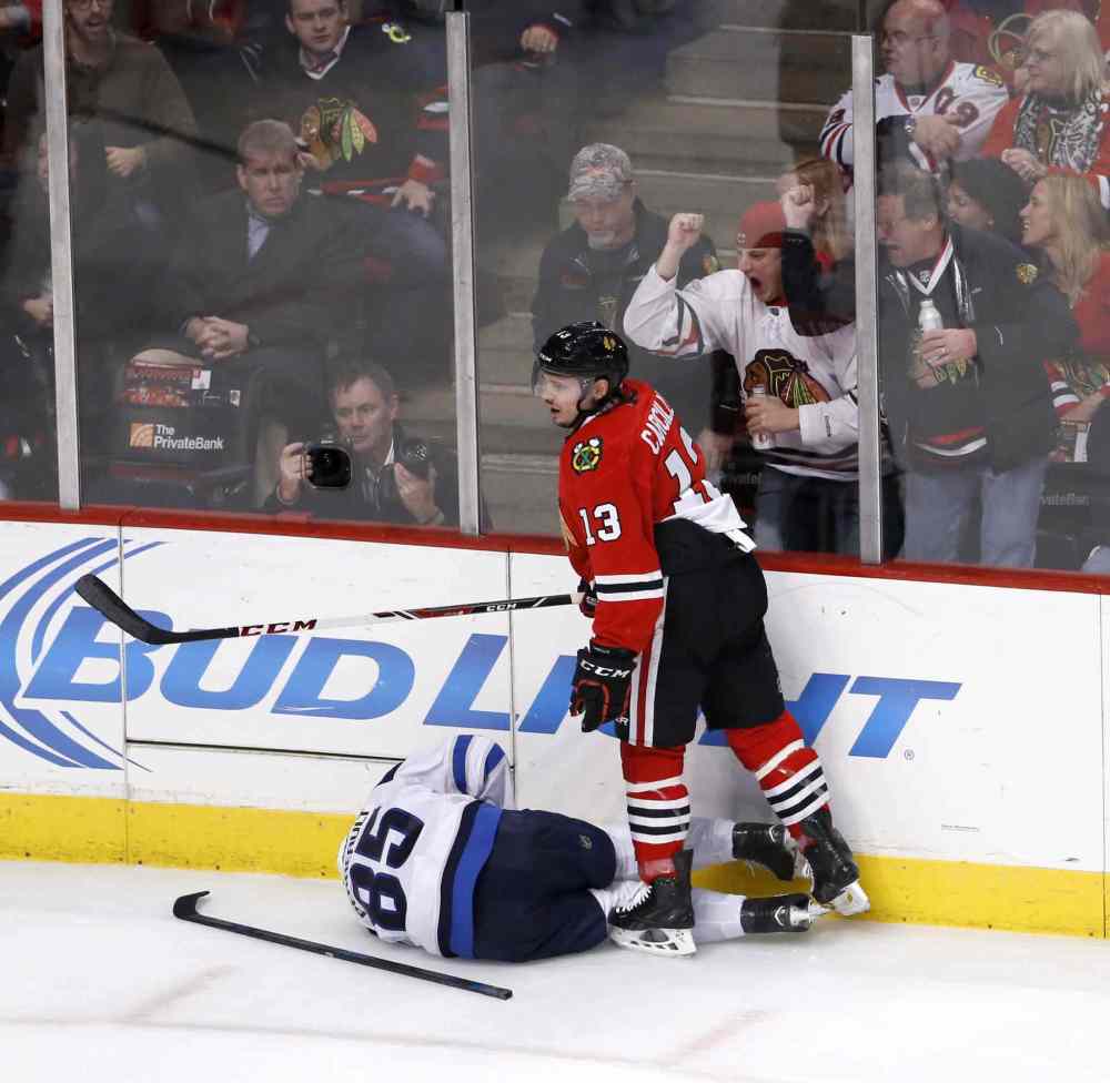 Charles Rex Arbogast / The Associated Press
Chicago Blackhawks left wing Daniel Carcillo (13) stands over injured Winnipeg Jets centre Mathieu Perreault (85) after a hit during the second period.