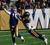 Melissa Tait / Winnipeg Free Press
Bombers' quarterback Max Hall throws before Tiger-Cats' defensive end Brandon Boudreaux takes him down in the first quarter Saturday at Investors Group Field.