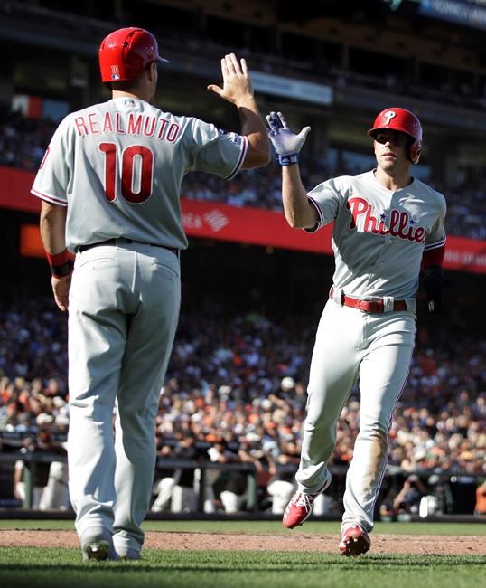 Philadelphia Phillies' Scott Kingery, right, is congratulated by J.T. Realmuto (10) after scoring against the San Francisco Giants in the third inning of a baseball game Sunday, Aug. 11, 2019, in San Francisco. (AP Photo/Ben Margot)