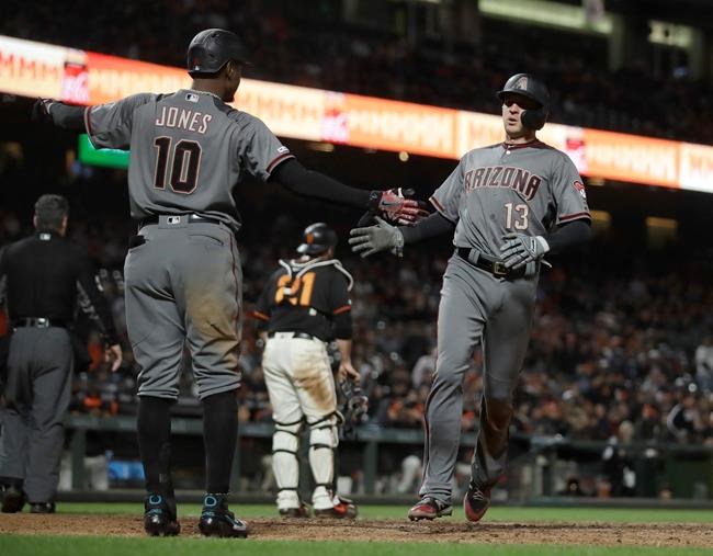Arizona Diamondbacks' Nick Ahmed, right, is congratulated by Adam Jones (10) after scoring against the San Francisco Giants during the eighth inning of a baseball game Saturday, June 29, 2019, in San Francisco. (AP Photo/Ben Margot)