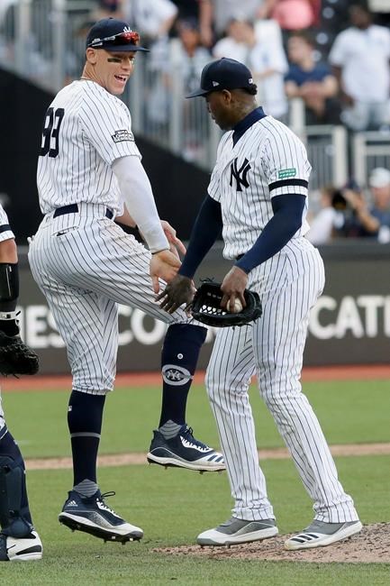 New York Yankees right fielder Aaron Judge, left, and relief pitcher Aroldis Chapman celebrate after their 12-8 win during a baseball game in London, Sunday, June 30, 2019. (AP Photo/Tim Ireland)