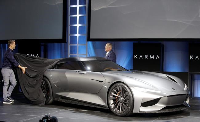 Karma Automotive Andreas Thurner, Vice President for Global Design and Architecture, left, and Todd George, VP of Platform Engineering at Karma Automotive, unveil Karman Vision SC2 concept vehicle at Automobility LA Auto Show in Los Angeles Tuesday, Nov. 19, 2019. (AP Photo/Damian Dovarganes)