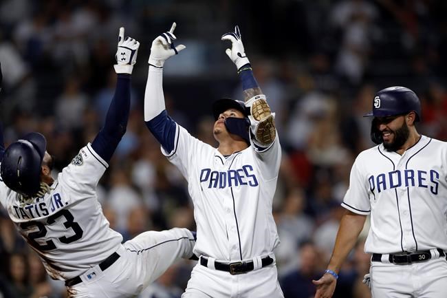 San Diego Padres' Manny Machado, celebrates with Fernando Tatis Jr. (23) and Eric Hosmer, right, after hitting a three-run home run during the second inning against the St. Louis Cardinals in a baseball game Saturday, June 29, 2019, in San Diego. (AP Photo/Gregory Bull)