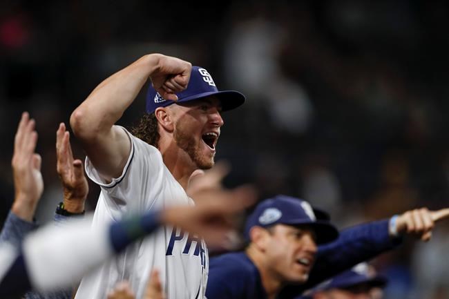 The San Diego Padres' Chris Paddack reacts from the dugout after teammate Joey Lucchesi hit an RBI-single during the second inning of a baseball game against the Tampa Bay Rays Monday, Aug. 12, 2019, in San Diego. (AP Photo/Gregory Bull)