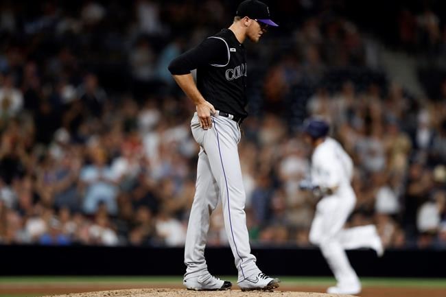 Colorado Rockies starting pitcher Jeff Hoffman, center, walks on the mound as San Diego Padres' Manny Machado, right, runs the bases after hitting a two-run home run during the sixth inning of a baseball game Saturday, Sept. 7, 2019, in San Diego. (AP Photo/Gregory Bull)