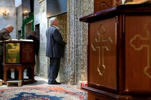 In this Jan. 18, 2019 photo, a men pray at Mart Shmony Church, an orthodox church in the northern Iraqi town of Bartella, Iraq. Two years after it was liberated from Islamic State militants, only a fraction of Christian residents have returned to Bartella. Many fear intimidation by the town‚Äôs population of Shabak, a Shiite Muslim ethnic group who dominate the militias that now run Bartella. (AP Photo/Fay Abuelgasim)