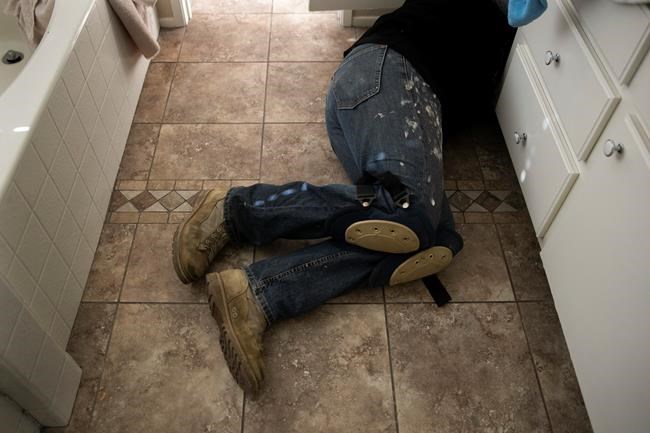 Chris George, a federal employee furloughed from his job as a forestry technician supervisor for the U.S. Department of Agriculture Forest Service, fixes a bathroom faucet, Saturday, Jan. 19, 2019, in Fontana, Calif. The 48-year-old federal worker has been working as a handyman and driving for Lyft to make ends meet since the government shutdown began. (AP Photo/Jae C. Hong)