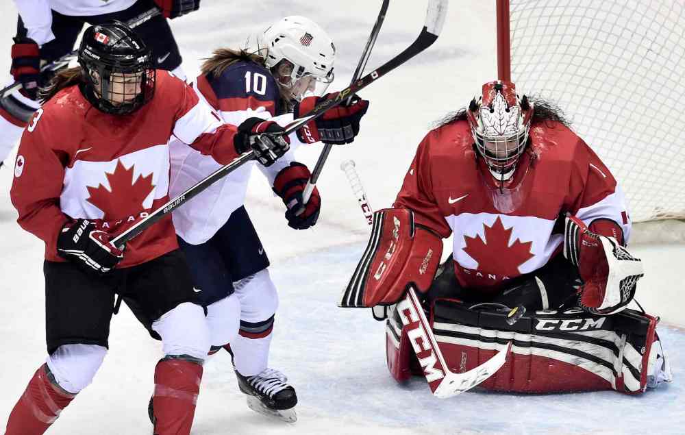 Nathan Denette / The Canadian Press
Goalie Shannon Szabados makes a save as teammate Jocelyne Larocque (left) ties up United States' Meghan Duggan during the first period in Sochi, Russia.