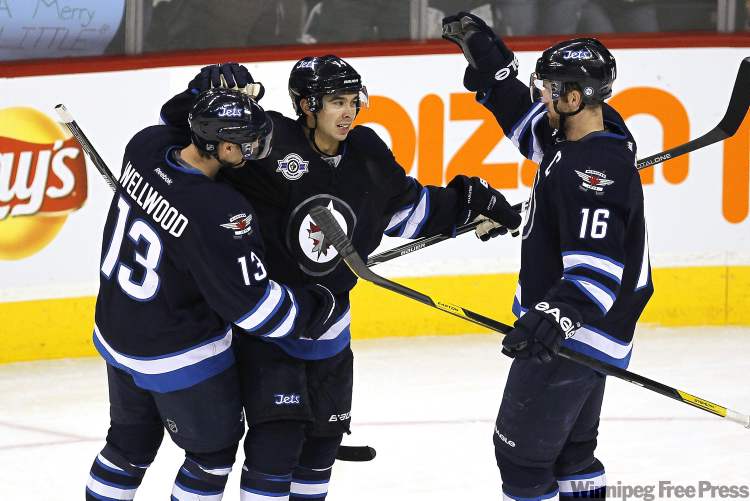 John Woods / The Canadian Press
Winnipeg Jets forward Kyle Wellwood (13), forward Tim Stapleton (14), and forward Andrew Ladd (16) celebrate Stapleton's goal against the Carolina Hurricanes during second-period NHL action in Winnipeg on Friday.