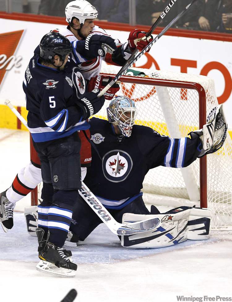 John Woods / The Canadian Press
Winnipeg Jets goaltender Chris Mason (50) gets a glove on the puck as Jets defenceman Mark Stuart (5) and Carolina Hurricanes forward Eric Staal (12) fight for position during third-period NHL action in Winnipeg on Friday.
