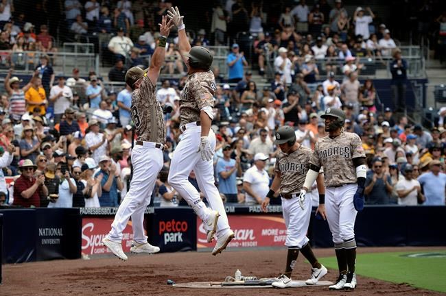 San Diego Padres' Hunter Renfroe, second from left, is congratulated by Austin Hedges, left, after hitting a three-run home run during the third inning of a baseball game against the San Francisco Giants, Sunday, July 28, 2019, in San Diego. (AP Photo/Orlando Ramirez)