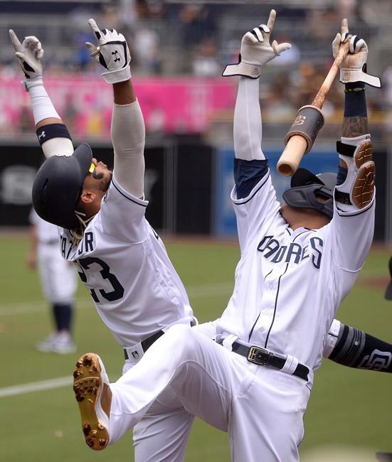 San Diego Padres' Fernando Tatis Jr., left, celebrates with Manny Machado after hitting a home run during the first inning of a baseball game against the Baltimore Orioles Tuesday, July 30, 2019, in San Diego. (AP Photo/Orlando Ramirez)