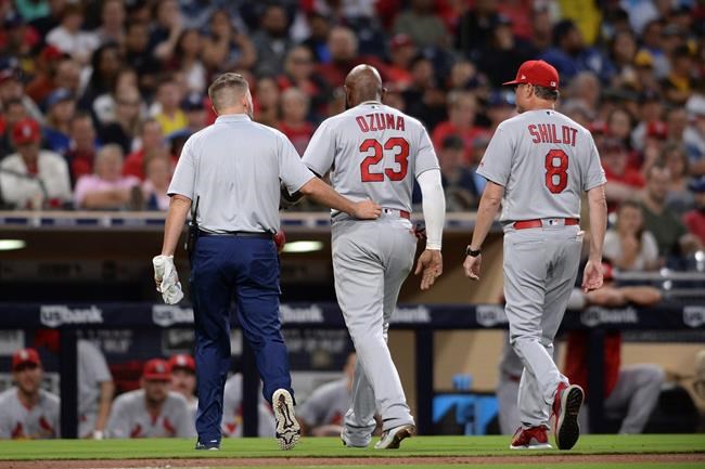 St. Louis Cardinals' Marcell Ozuna, center, leaves the field accompanied by a trainer and Mike Shildt during the third inning of a baseball game against the San Diego Padres, Friday, June 28, 2019, in San Diego. (AP Photo/Orlando Ramirez)