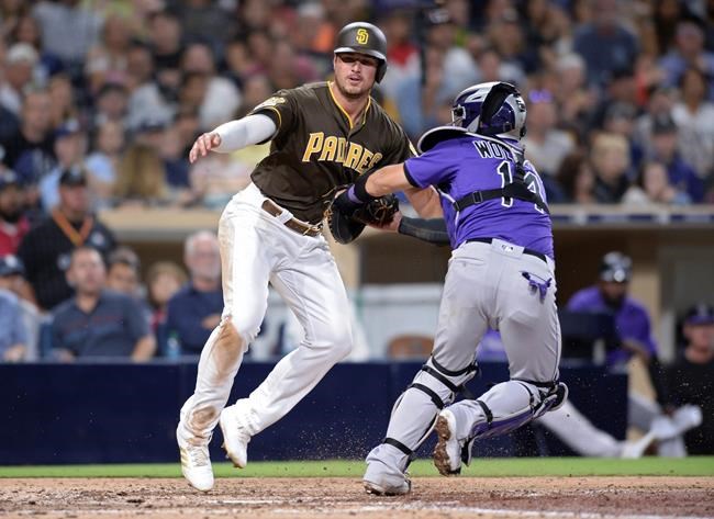 San Diego Padres' Hunter Renfroe, left, is tagged out at home by Colorado Rockies catcher Tony Wolters during the sixth inning of a baseball game Friday, Aug. 9, 2019, in San Diego. (AP Photo/Orlando Ramirez)