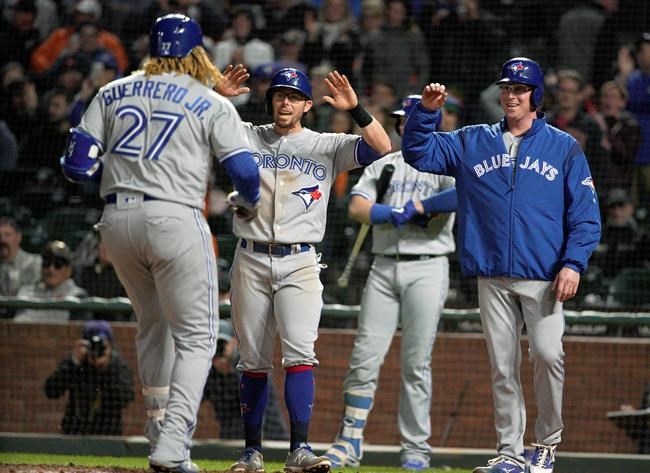 Toronto Blue Jays' Eric Sogard, center, and Trent Thornton, right, wait at home plate for Vladimir Guerrero Jr. (27) after he hit a three-run home run against the San Francisco Giants during the sixth inning of a baseball game in San Francisco, Tuesday, May 14, 2019. (AP Photo/Tony Avelar)