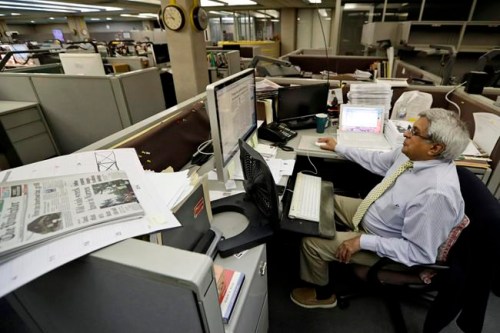 In this Wednesday, Aug. 7, 2019, photo, Bertram de Souza works on a story for The Vindicator newspaper in Youngstown, Ohio. The Youngstown paper announced in June it would cease publication Saturday, Aug. 31, because of financial struggles, but the paper will be printed by the Tribune Chronicle, which has bought The Vindicator name, subscriber list and website from owners of the Youngstown publication. (AP Photo/Tony Dejak)