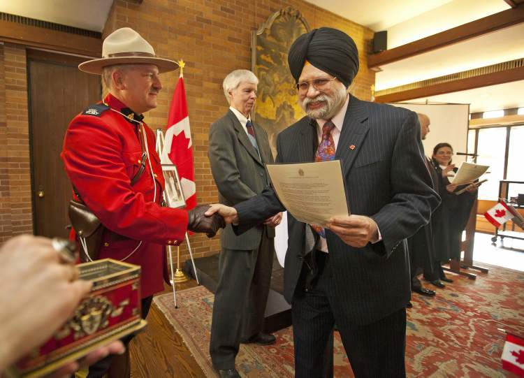Postmedia JENNIFER ROBERTS FOR
Jagdev Singh, originally from India, shakes Constable Terry Russel's hand after becoming a Canadian citizen during a Citizenship Ceremony at Massey College in Toronto on February 8, 2012.