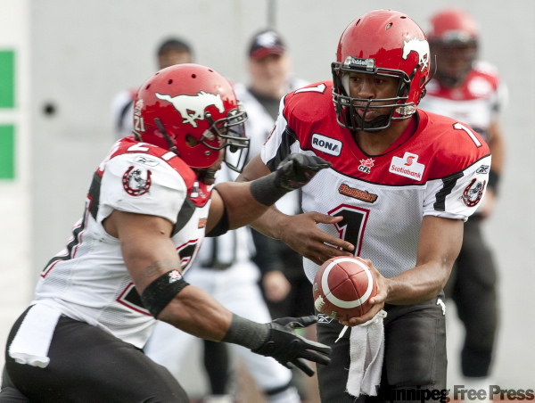 PAUL CHIASSON / THE CANADIAN PRESS
Stampeders quarterback Henry Burris hands off to running back Joffrey Reynolds in the Montreal game Monday. The Stamps lost 32-11 to the Alouettes.