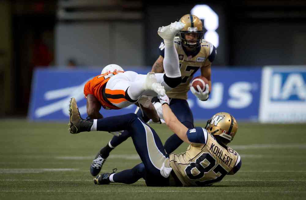 Darryl Dick / The Canadian Press
B.C. Lions' Dante Marsh, left, collides with Winnipeg Blue Bombers' Rory Kohlert, bottom, as Nick Moore, back, carries the ball during the first half of a CFL football game in Vancouver, B.C., on Friday July 25, 2014.