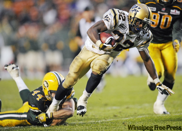 JIMMY JEONG / THE CANADIAN PRESS
Blue Bombers’ running back Fred Reid runs the ball past Edmonton’s Mark Restelli for a touchdown during the second half on Thursday.