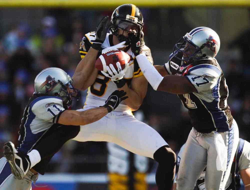 JOHN MAHONEY / THE GAZETTE FILES
Hamilton Tiger-Cats Chris Bauman makes a catch in between Montreal Alouettes Chip Cox (left) and Billy Parker during first half of Canadian Football League game in Montreal Sunday, October 18, 2009.