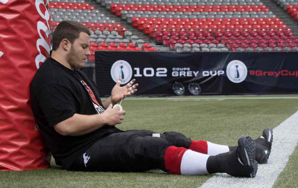 PAUL CHIASSON / THE CANADIAN PRESS FILES
Calgary Stampeders' offensive lineman Pierre Lavertu tapes his hands prior to the 102nd Grey Cup against the Hamilton Tiger-Cats in Vancouver, B.C. Sunday, Nov. 30, 2014.