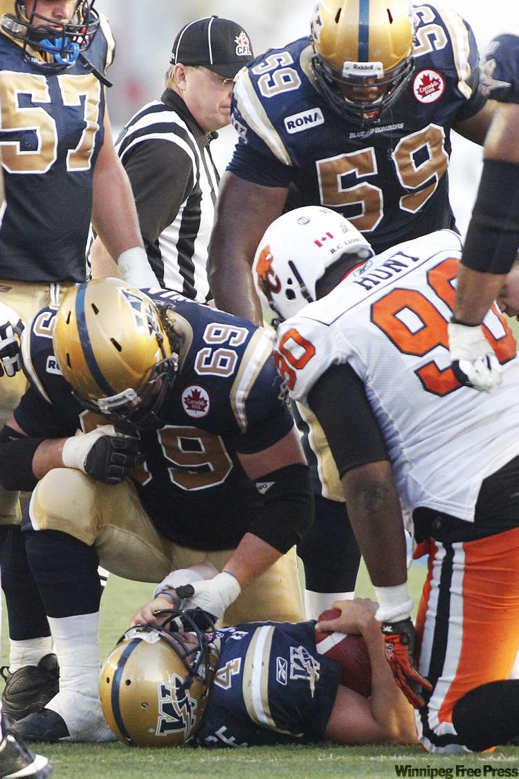 John Woods / The Canadian Press
Winnipeg Blue Bombers' Buck Pierce (4) lies on the ground after being hit hard by B.C. Lions' Solomon Elimimian in second half CFL action in Winnipeg, Thursday, July 28, 2011. Pierce was pulled from the game after this set of plays and replaced by Alex Brink (7).
