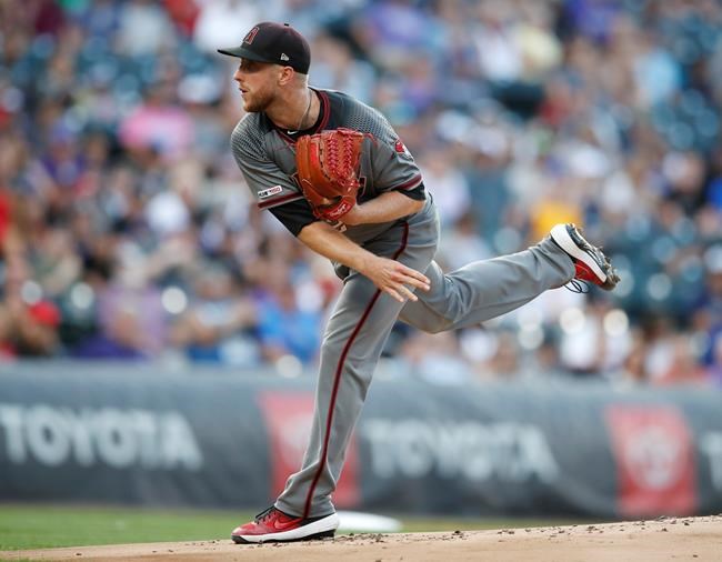 Arizona Diamondbacks starting pitcher Merrill Kelly works against the Colorado Rockies in the first inning of a baseball game Monday, Aug. 12, 2019, in Denver. (AP Photo/David Zalubowski)
