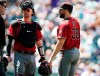 From left, umpire Chris Conroy confers with Arizona Diamondbacks catcher Carson Kelly and starting pitcher Robbie Ray as he waits to be pulled from the mound before the start of the bottom of the third inning of a baseball game against the Colorado Rockies Wednesday, Aug. 14, 2019, in Denver. Relief pitcher Matt Andriese took over on the mound for Ray. (AP Photo/David Zalubowski)