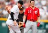 Cincinnati Reds' Derek Dietrich, right, ends up with his chain on his chin after reaching second base on a double as Colorado Rockies shortstop Trevor Story, left, applies a late tag in the second inning of a baseball game Sunday, July 14, 2019, in Denver.(AP Photo/David Zalubowski)