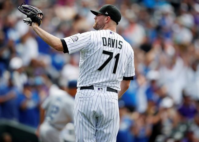 Colorado Rockies' Wade Davis waits for a new ball after giving up a three-run home run to Los Angeles Dodgers' Will Smith during the ninth inning of a baseball game Wednesday, July 31, 2019, in Denver. The Dodgers won 5-1. (AP Photo/David Zalubowski)