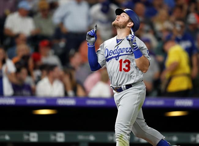 Los Angeles Dodgers' Max Muncy gestures as he crosses home plate after hitting a two-run home run off Colorado Rockies relief pitcher Jairo Diaz during the seventh inning of a baseball game Thursday, June 27, 2019, in Denver. (AP Photo/David Zalubowski)