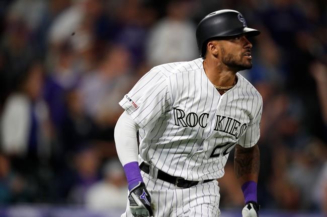 Colorado Rockies' Ian Desmond watches his grand slam off San Diego Padres relief pitcher Robbie Erlin during the fifth inning of a baseball game Saturday, June 15, 2019, in Denver. (AP Photo/David Zalubowski)