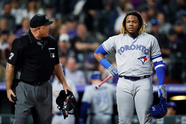 Home plate umpire Brian O'Nora, left, talks with Toronto Blue Jays' Vladimir Guerrero Jr. after Guerrero was called out on strikes to end the top of the eighth inning of a baseball game against the Colorado Rockiesm Saturday, June 1, 2019, in Denver. (AP Photo/David Zalubowski)