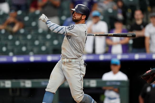 San Diego Padres' Greg Garcia follows the flight of his triple to drive in two runs off Colorado Rockies relief pitcher Wade Davis in the ninth inning of a baseball game Sunday, June 16, 2019, in Denver. (AP Photo/David Zalubowski)