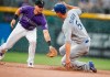 Colorado Rockies second baseman Ryan McMahon, left, turns to apply a late tag as Los Angeles Dodgers' Corey Seager advances to second base on a sacrifice fly hit by Justin Turner in the first inning of a baseball game Tuesday, July 30, 2019, in Denver. (AP Photo/David Zalubowski)