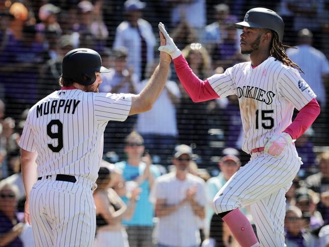 Colorado Rockies' Daniel Murphy (9) congratulates teammate Raimel Tapia (15) after Tapia hit a home run that also scored him in the seventh inning of a baseball game against the San Diego Padres in Denver, Sunday, May 12, 2019. (AP Photo/Joe Mahoney)