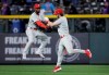 Philadelphia Phillies right fielder Bryce Harper, right, dunks his glove into the arms of Phillies center fielder Andrew McCutchen (22) after beating the Colorado Rockies in a baseball game in Denver, Saturday, April 20, 2019. Philadelphia won 8-5.(AP Photo/Joe Mahoney)