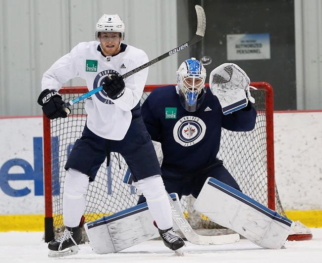 Winnipeg Jets' Andrew Copp (9) tries to tip pucks past goaltender Eric Comrie (1) during practice in Winnipeg, Monday, April 8, 2019. Goalie Eric Comrie and the Winnipeg Jets agreed to a two-year deal on Saturday with an average annual value of $700,000 in the NHL. THE CANADIAN PRESS/John Woods