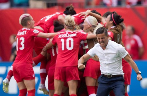 Canada coach John Herdman, right, celebrates as Josee Belanger, back, is mobbed by her teammates after scoring against Switzerland during the second half of the FIFA Women's World Cup round of 16 soccer action in Vancouver, B.C., on Sunday, June 21, 2015. As the Women's World Cup wound down, Herdman pointed to his team's very first game when asked about his favourite memories from the tournament. THE CANADIAN PRESS/Darryl Dyck