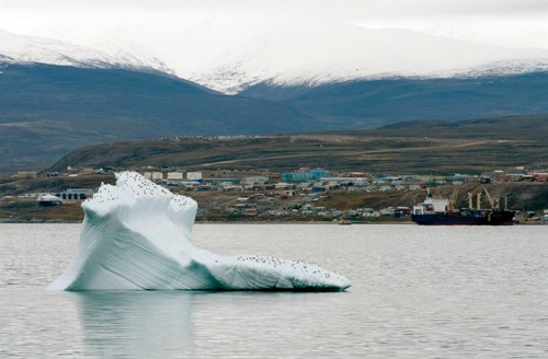 Ice floats past a cargo ship and the hamlet of Pond Inlet on August 24, 2014. THE CANADIAN PRESS/Adrian Wyld