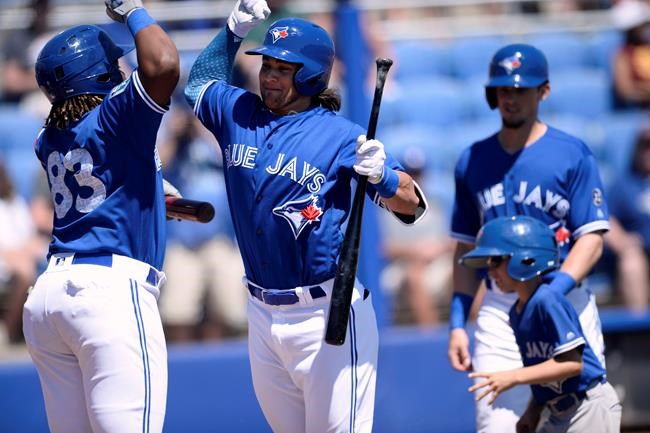 Toronto Blue Jays' Vladimir Guerrero Jr., left, and Bo Bichette, right, celebrate after Bichette's two-run home run during the first inning of a spring training baseball game against the Canada Junior National Team Saturday, March 17, 2018, in Dunedin, Fla. Vladimir Guerrero Jr. and Bo Bichette are among the 15 players announced as non-roster invitees to the Blue Jays' major league spring training camp. THE CANADIAN PRESS/AP, Jason Behnken