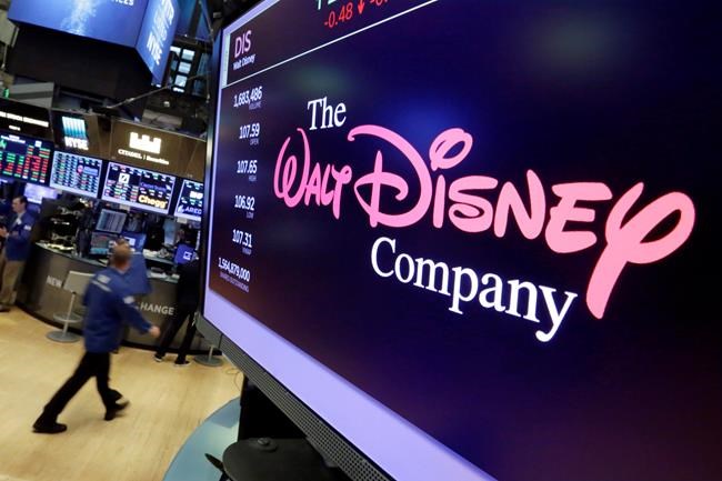 FILE - In this Monday, Aug. 7, 2017, file photo, The Walt Disney Co. logo appears on a screen above the floor of the New York Stock Exchange. Disney Plus has launched in Canada, becoming the newest arrival in the growing menu of TV options. THE CANADIAN PRESS/AP Photo/Richard Drew, File