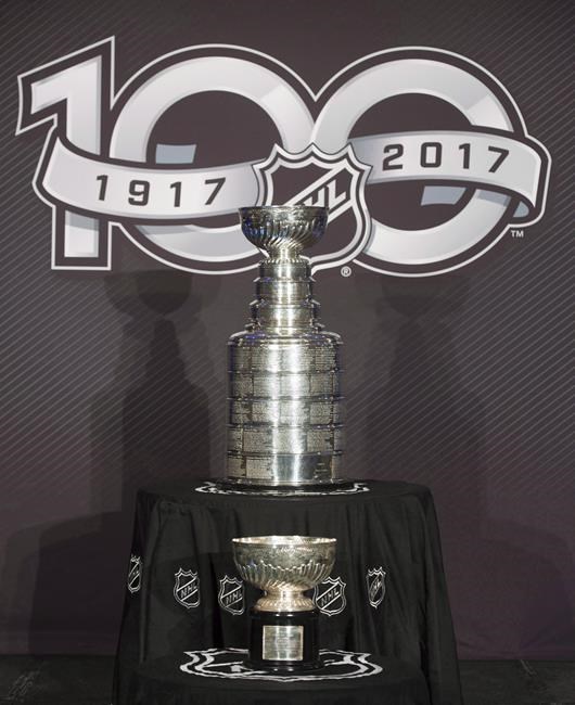 The Stanley Cup trophy and the original Stanley Cup are seen on display at an NHL announcement Friday March 17, 2017 in Ottawa. It's the grande dame of sports trophies, the oldest contested prize in North American athletics. The Stanley Cup will soon once again be awarded to hockey's top team, extending a tradition that dates back to 1893. THE CANADIAN PRESS/Adrian Wyld