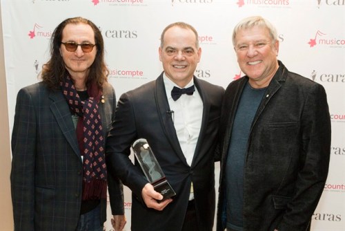 2016 MusiCounts Teacher of the Year Award recipient Don Bosse (centre) of Fredericton High School poses with Rush band members Geddy Lee (left) and Alex Lifeson in a recent handout photo. THE CANADIAN PRESS/ HO/Barry Roden