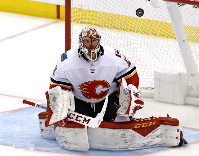Calgary Flames goaltender Mike Smith keeps his eye on a rebound during the first period of an NHL hockey game against the Pittsburgh Penguins in Pittsburgh, Saturday, Feb. 16, 2019. Mike Smith won't have to travel far to join his new team. The veteran goalie, who played with the Calgary Flames last season, signed a one-year contract with the Edmonton Oilers on Monday as NHL free agency opened. THE CANADIAN PRESS/AP, Gene J. Puskar