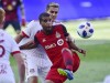 Toronto FC forward Jordan Hamilton (22) protects the ball from New York Red Bulls midfielder Aaron Long (33) during first half MLS soccer action in Toronto on Sunday, July 1, 2018. Toronto FC has re-signed forward Hamilton and midfielder Tsubasa Endoh.THE CANADIAN PRESS/Frank Gunn